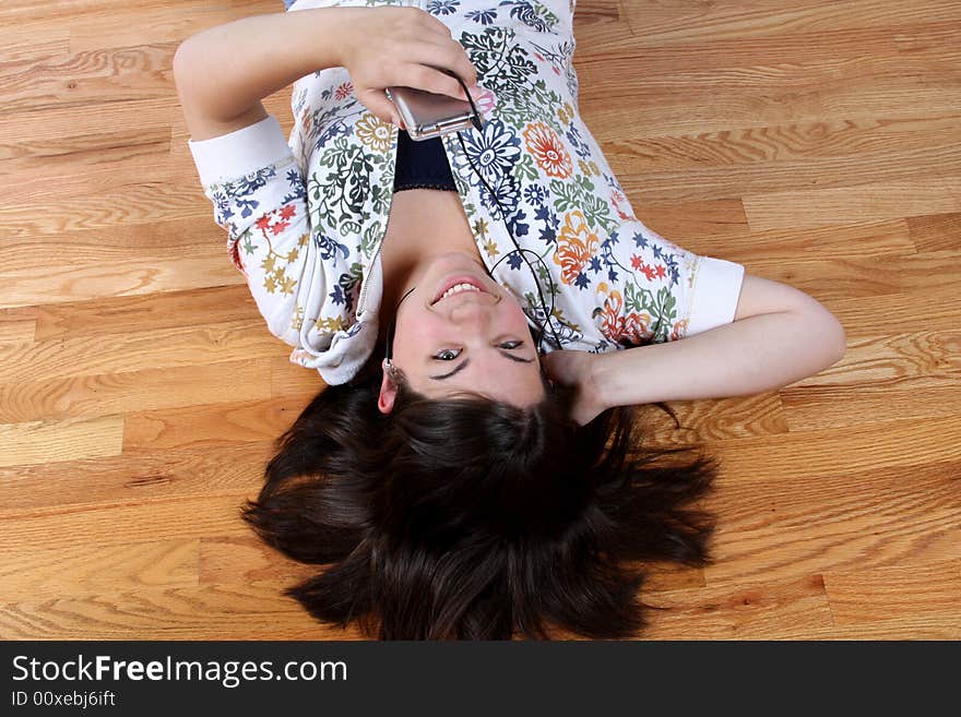 A teenage girl hanging out and listening to music on headphones.