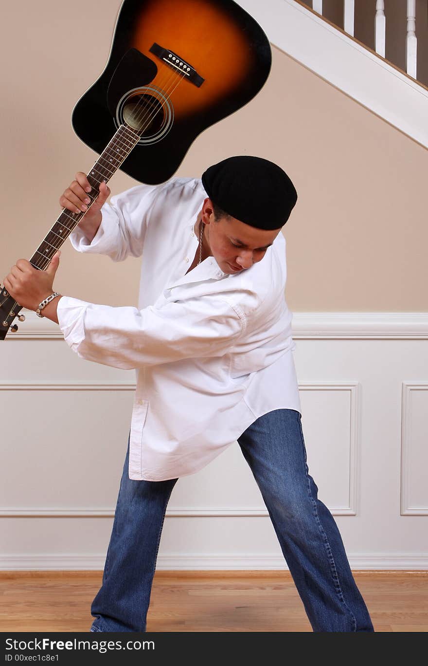 A young man swinging his guitar in frustration. A young man swinging his guitar in frustration.