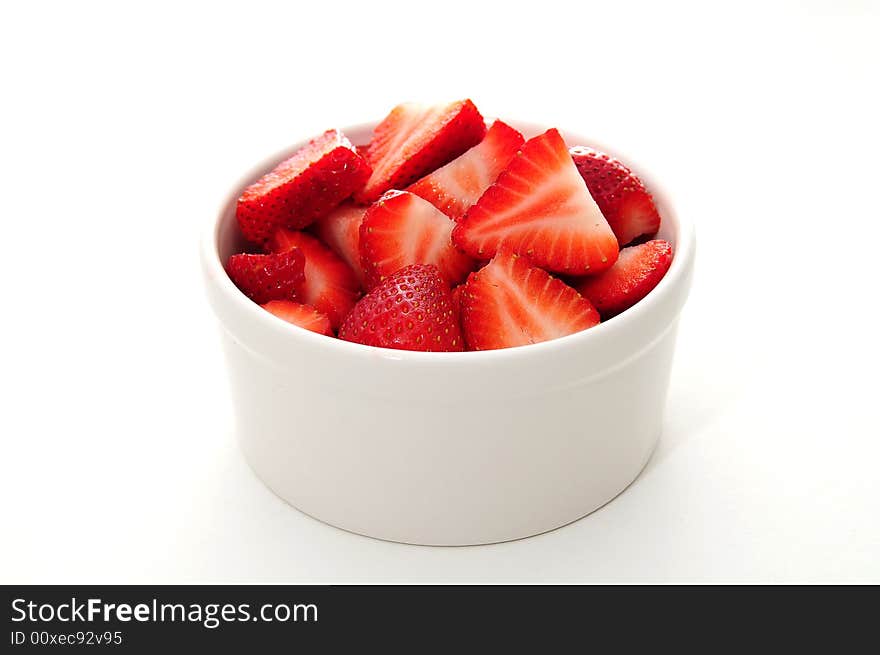 Cut Strawberies in a white ramekin bowl and isolated on a white background. Cut Strawberies in a white ramekin bowl and isolated on a white background