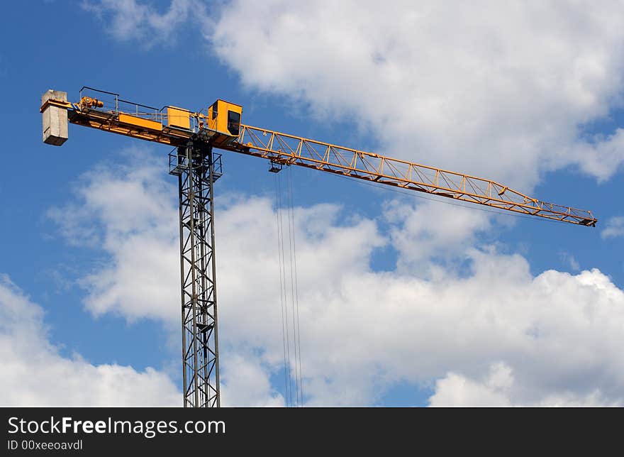 Lifting crane uder blue sky with clouds