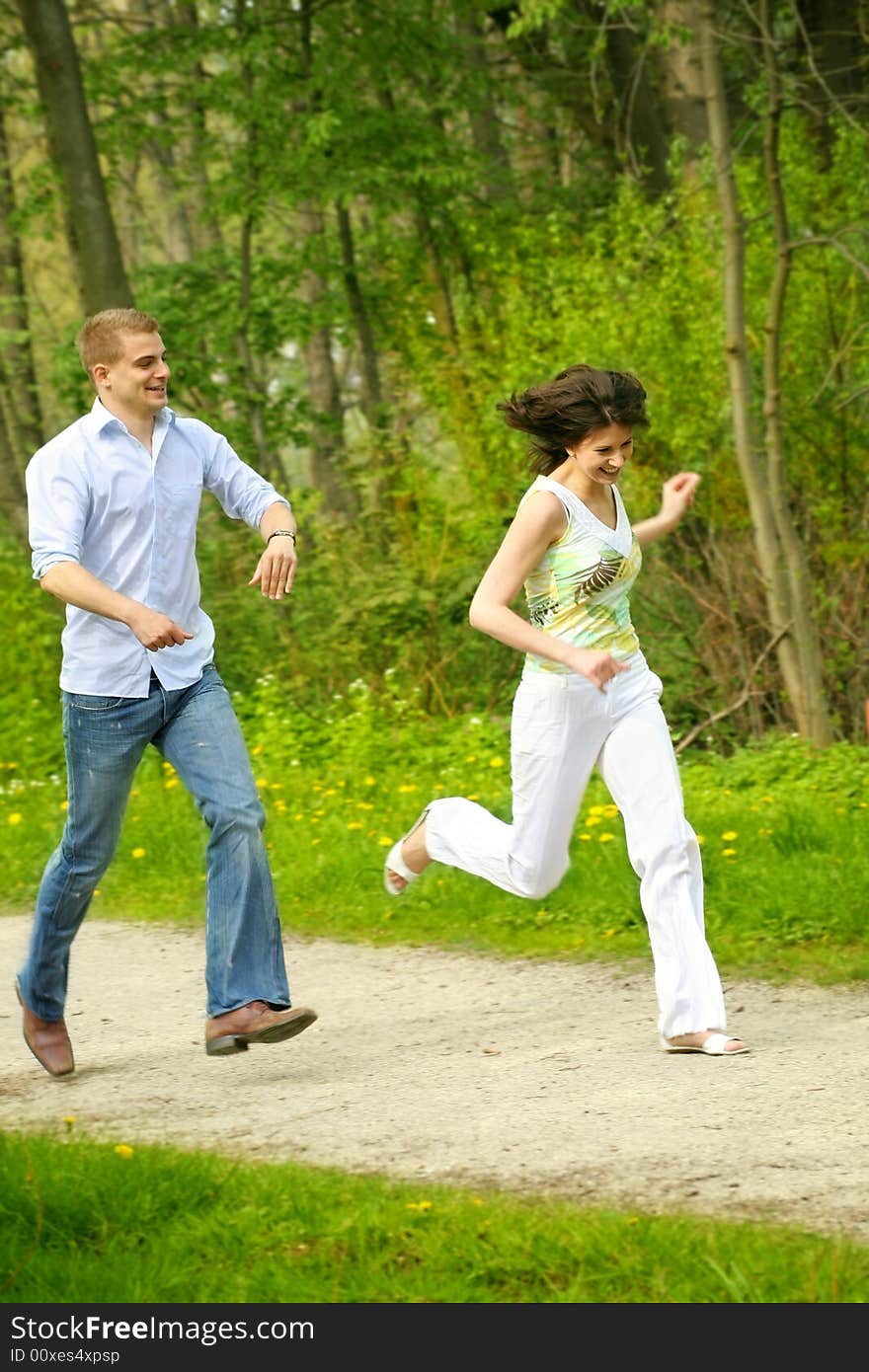 A young happy and smiling couple is playing tag. A young happy and smiling couple is playing tag