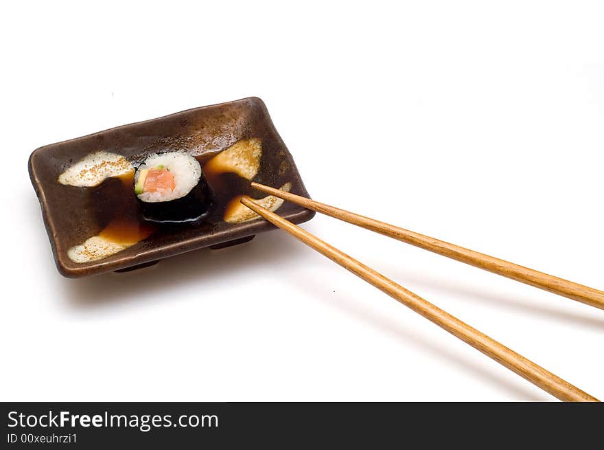 Salmon roll with avocado in soy on plate isolated om white. Salmon roll with avocado in soy on plate isolated om white