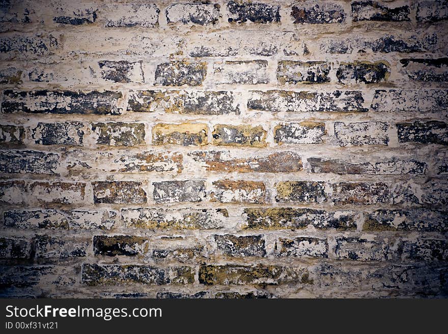 Old grungy wall of mixed bricks in cold tones ,chalk is comming off