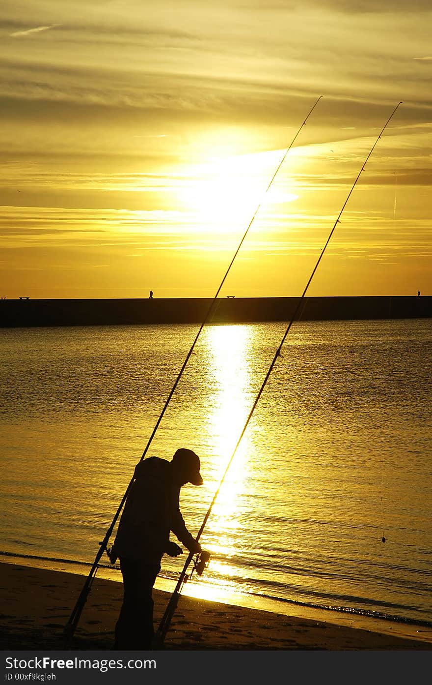 Fisherman at beach sunset