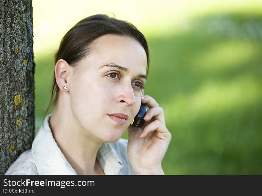 A woman on the phone in an casual outdoor setting. A woman on the phone in an casual outdoor setting