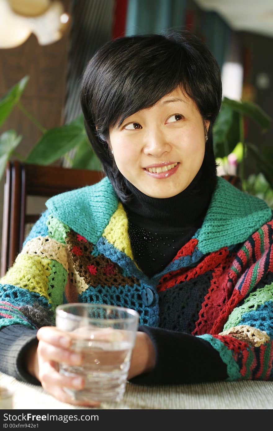 A beautiful young woman holding a cup of hot drink