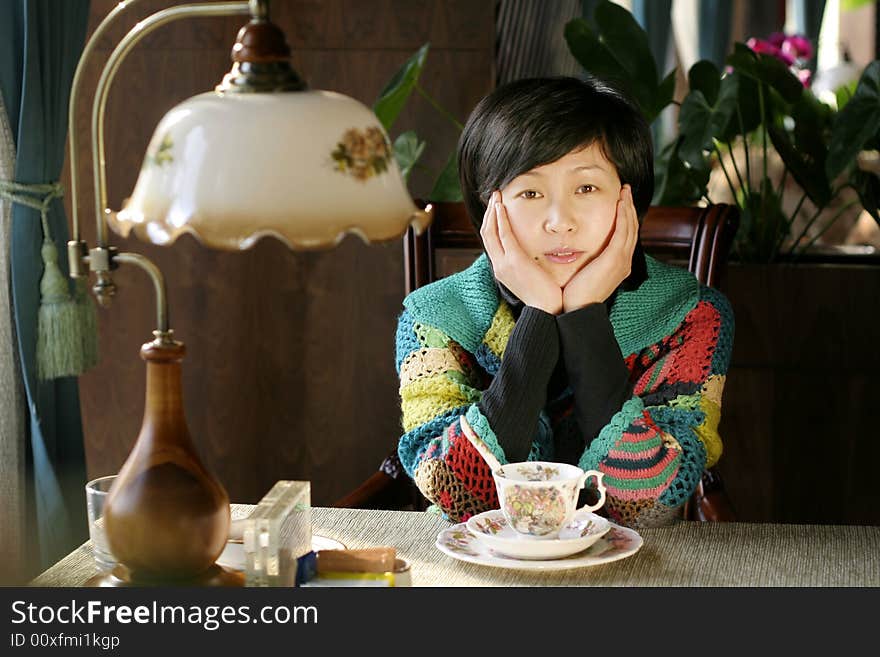 A beautiful young woman holding a cup of hot drink