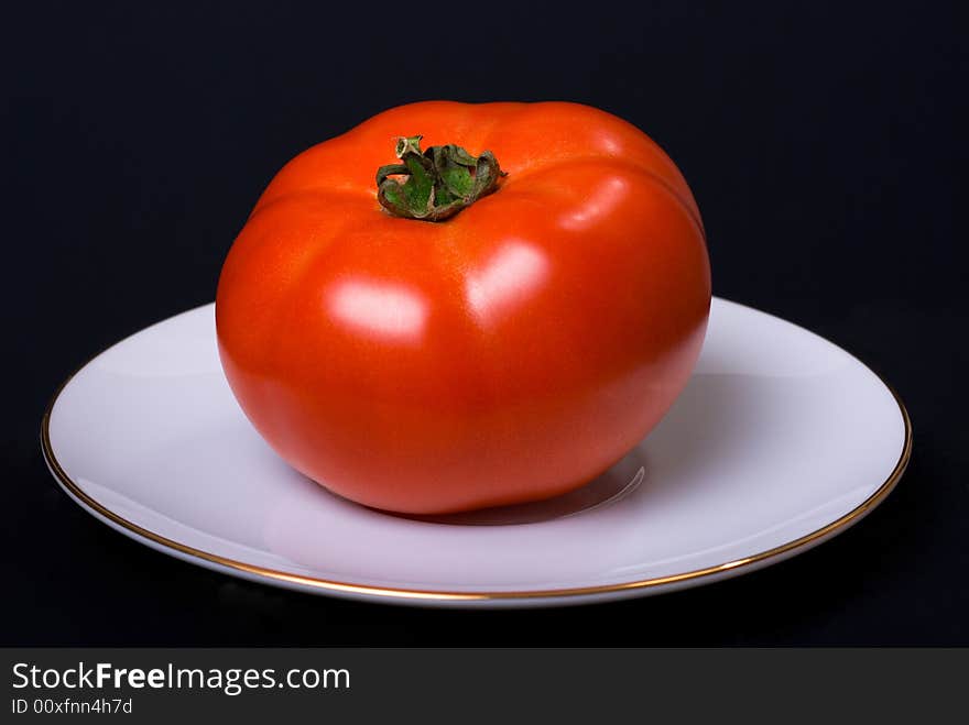 Beautiful tomato on the white plate. Beautiful tomato on the white plate