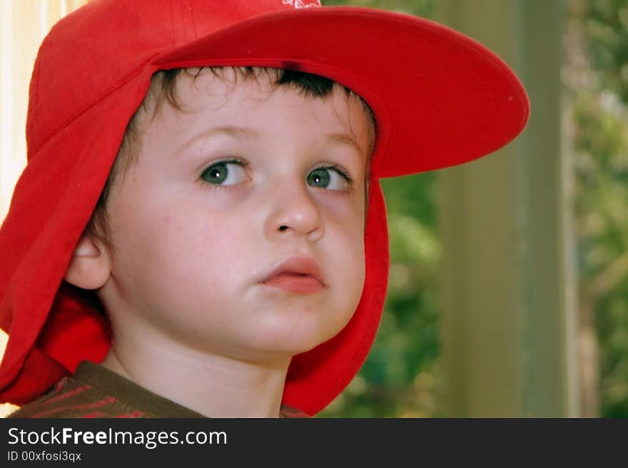 A young child daydreams lost in deep thought gazes into the middle distance perhaps in a home or a classroom environment - with copy space. A young child daydreams lost in deep thought gazes into the middle distance perhaps in a home or a classroom environment - with copy space