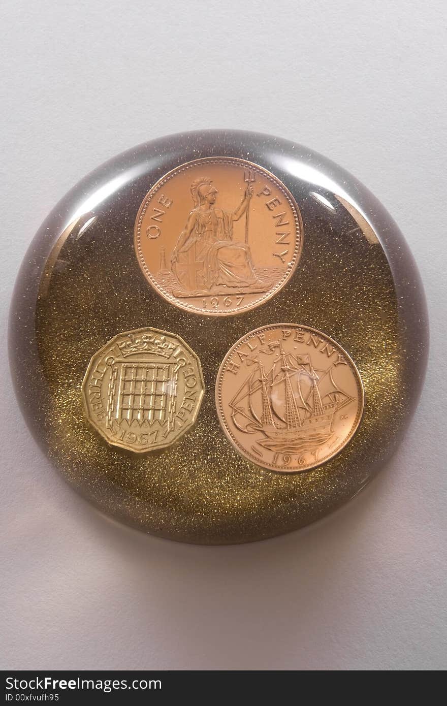 Glass paperweight with three coins