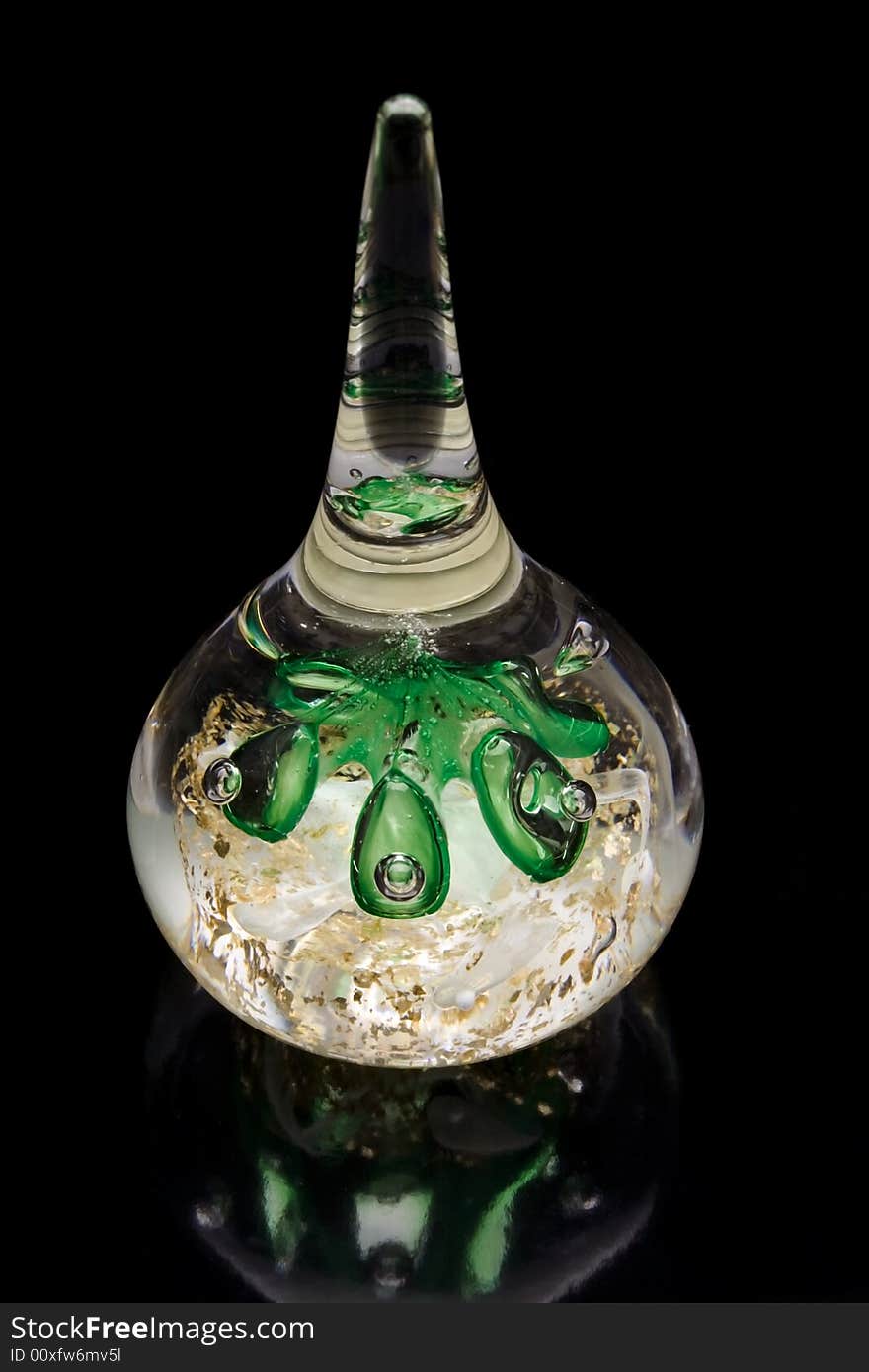 Glass paperweight filled with green bubbles on black