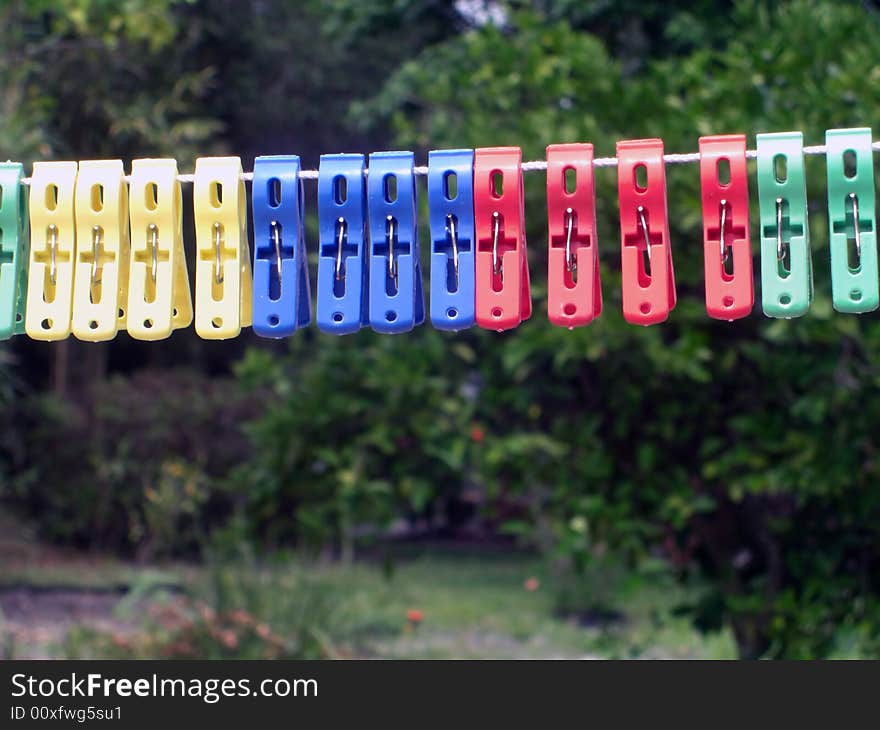 A colorful variety of pegs are on a clothes line. A colorful variety of pegs are on a clothes line