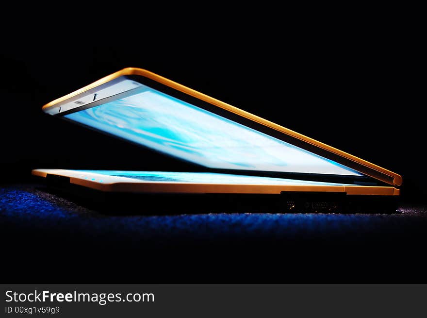 Half-closed gold laptop with blue bright screen