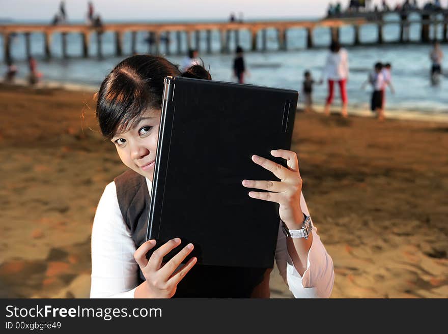 Business woman with laptop at beach