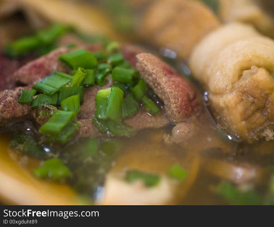 Asian dish of a tea flavored herbal clear  soup of  pork ribs, liver and stomach, served hot and sprinkled with chopped spring onions. Asian dish of a tea flavored herbal clear  soup of  pork ribs, liver and stomach, served hot and sprinkled with chopped spring onions.