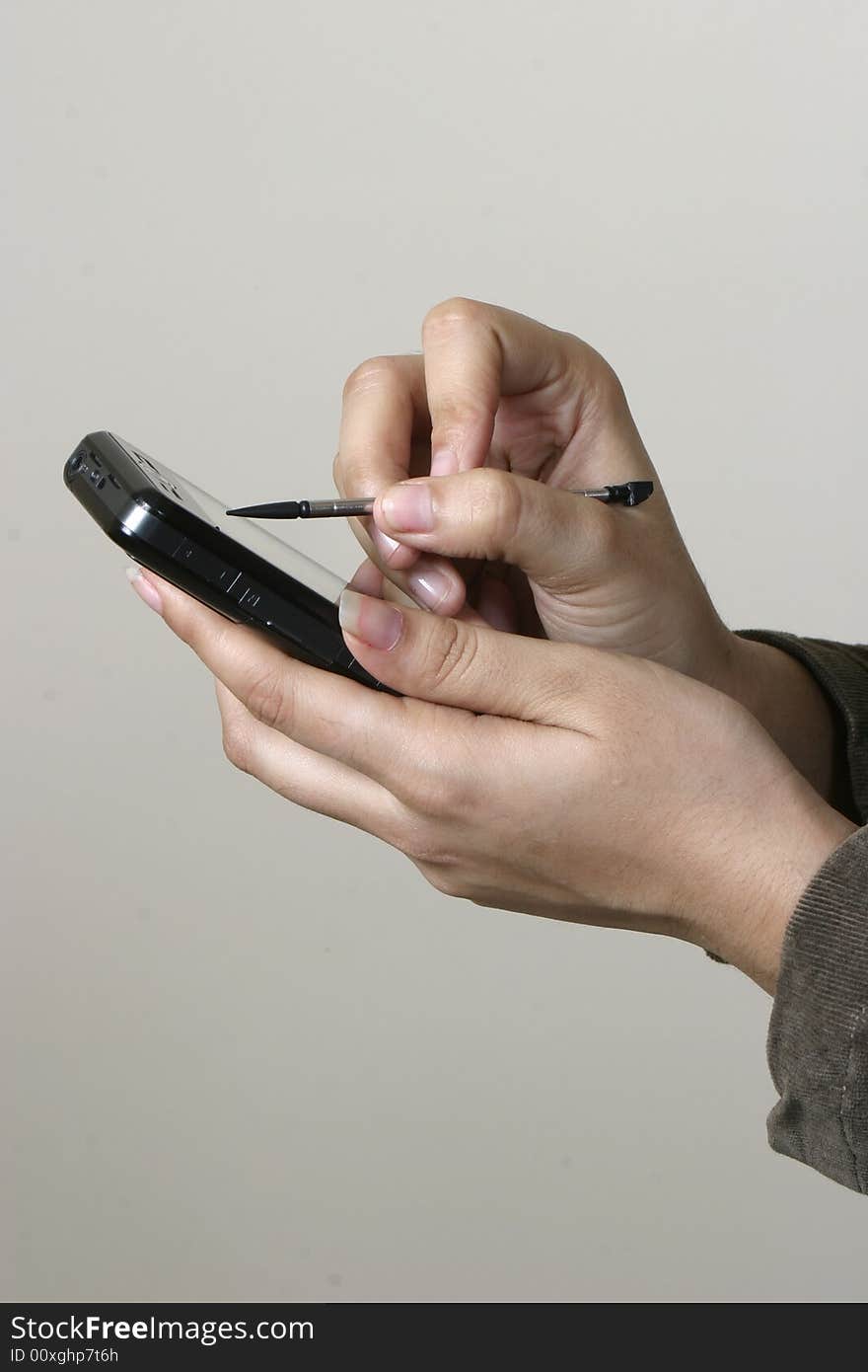 Close up of hands of young woman working on touchscreen phone with stylus. Close up of hands of young woman working on touchscreen phone with stylus