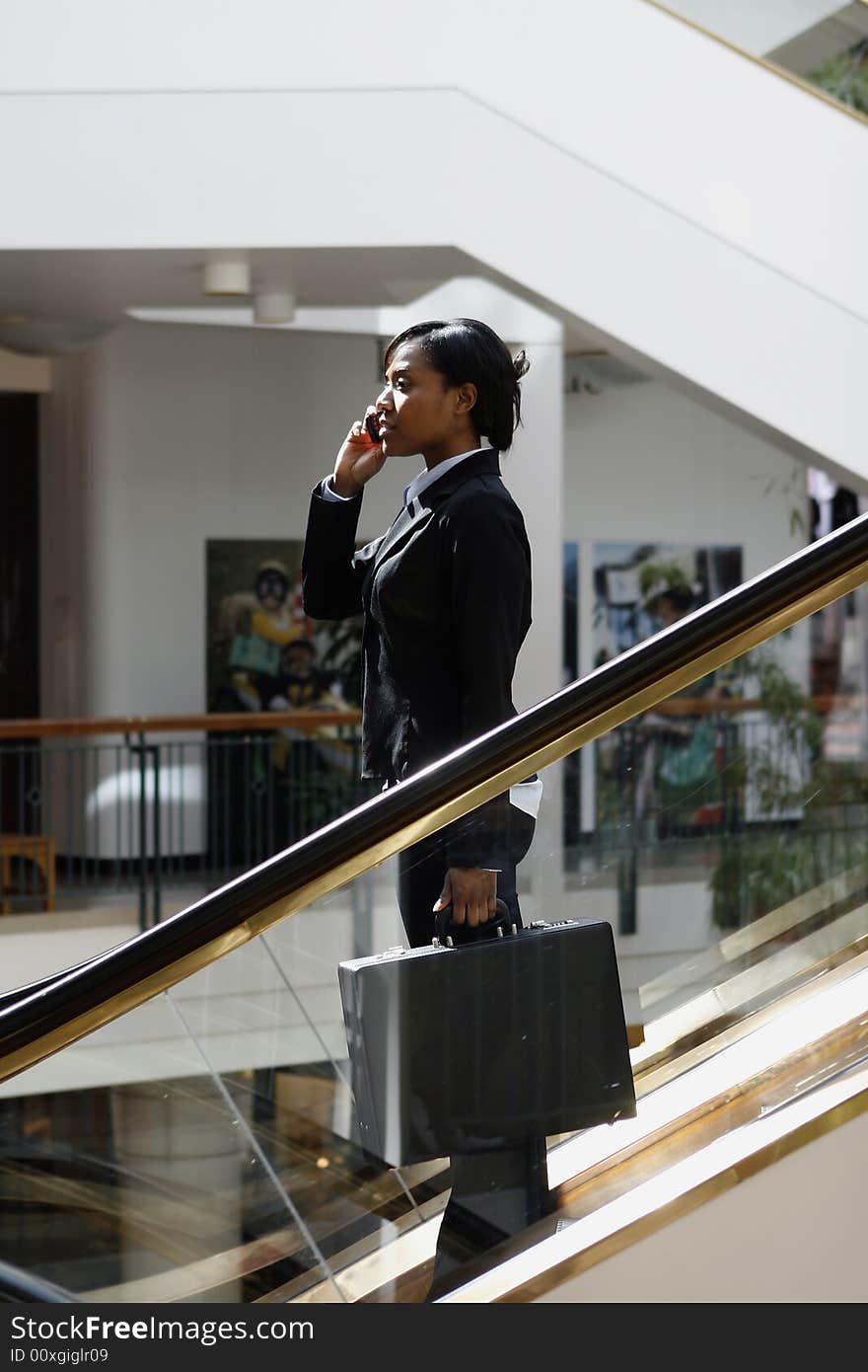 Businesswoman on Phone on Escalator - Vertical