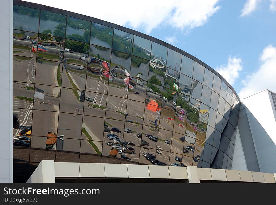 Reflection of a cloudy sky in glass wall of an office building