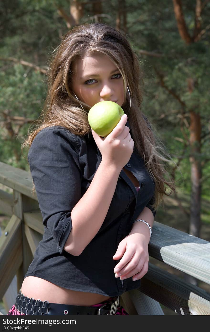 Young girl with apple on forest background