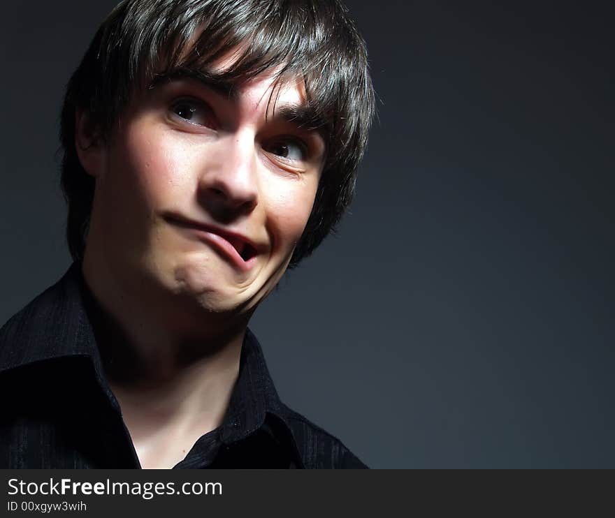 A portrait about a trendy attractive guy who is looking towards and he is moping. He is wearing a stylish black shirt. A portrait about a trendy attractive guy who is looking towards and he is moping. He is wearing a stylish black shirt.