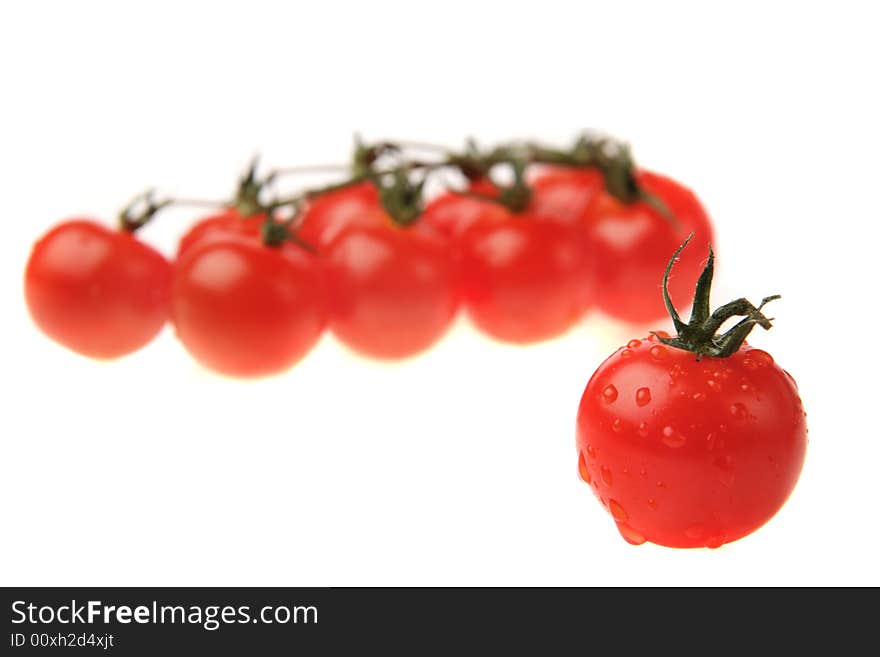 Fresh tomato in front and other tomatoes on the vine in the background. Fresh tomato in front and other tomatoes on the vine in the background