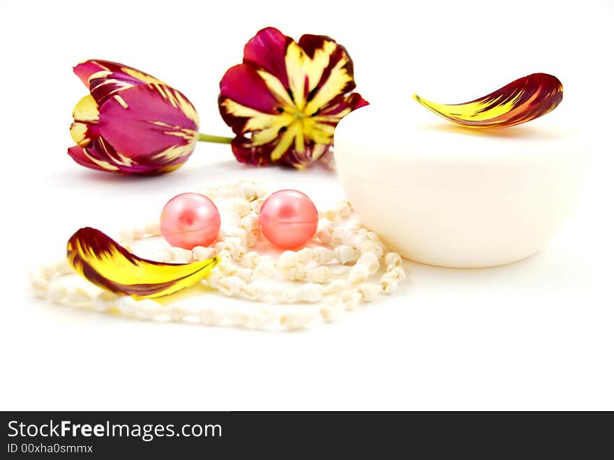 Bath oil arranged with tulip petal and cream