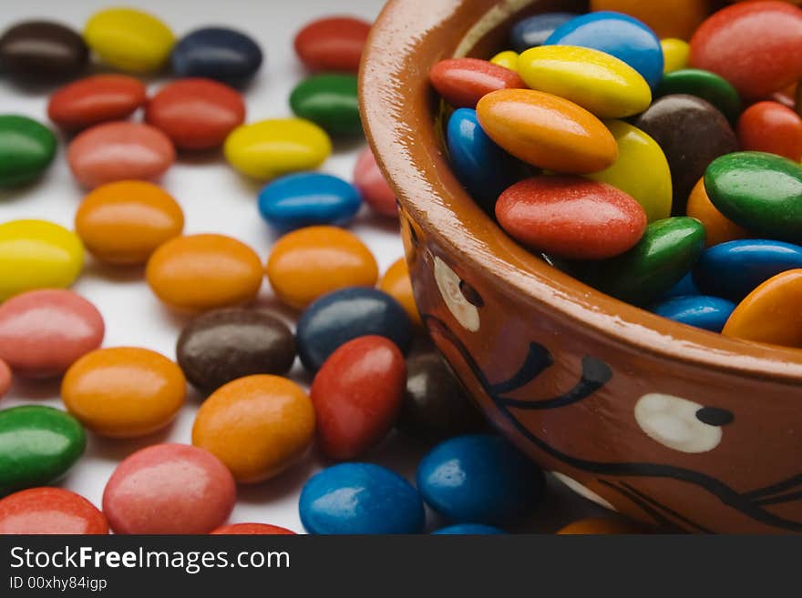 Multicolored sweet dragee. On white background and in pottery. Multicolored sweet dragee. On white background and in pottery.