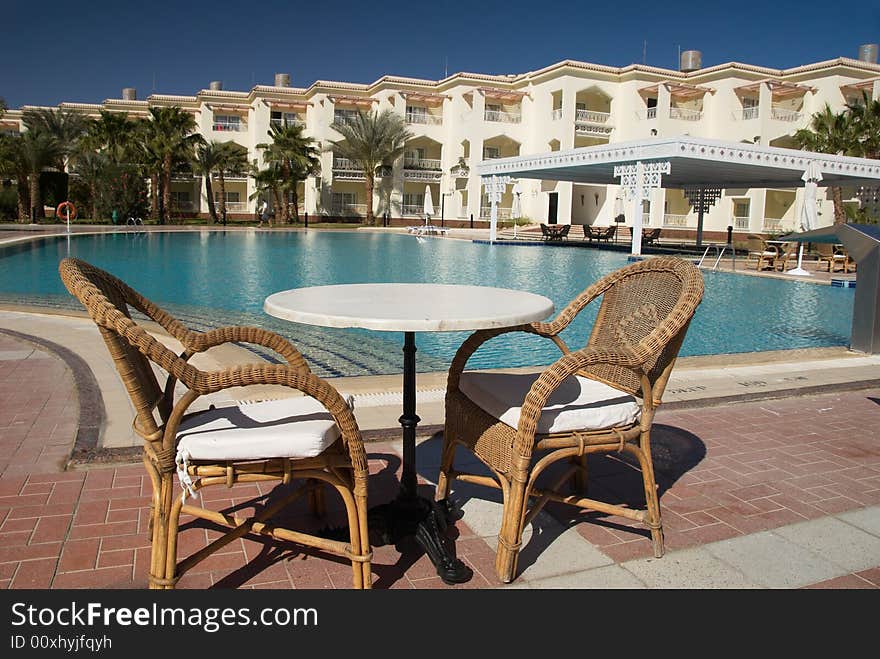 Table and chair near swimming pool in a tropical resort hotel