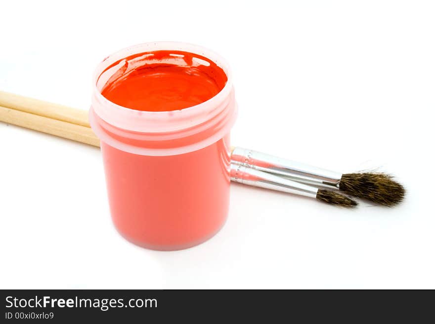 Red gouache and paintbrush isolated on white