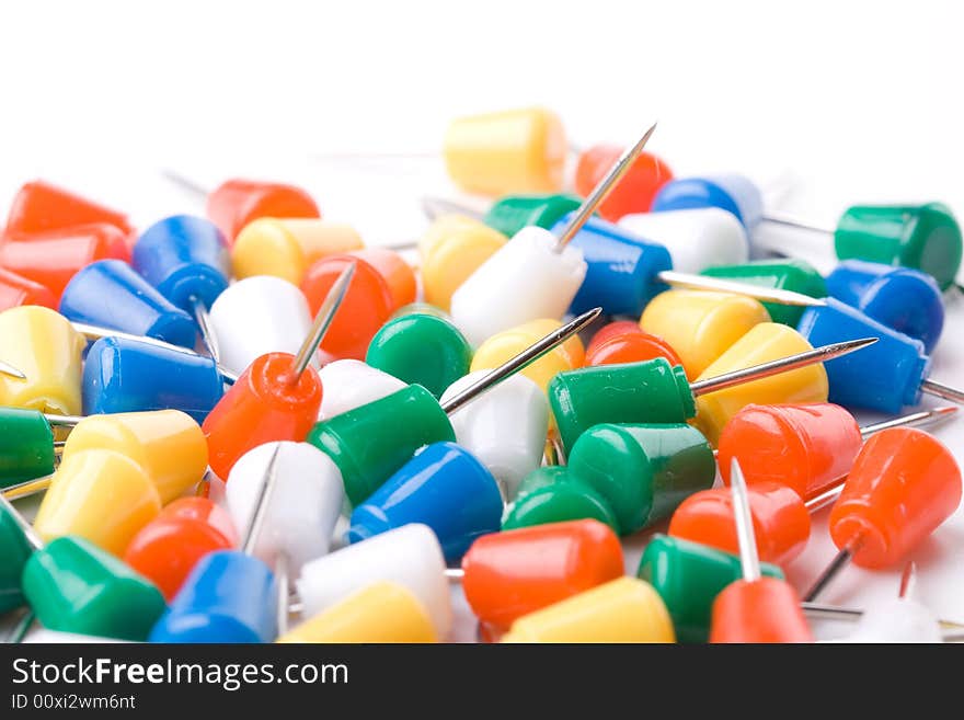 Colored pins on a white background. Close up. Selective focus. Colored pins on a white background. Close up. Selective focus.