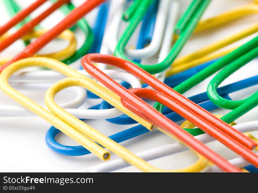 Colorful paper clips on a white background. Close up. Selective focus.