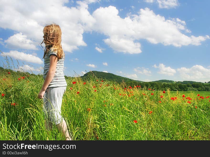 Happy child run on the field with red poppies