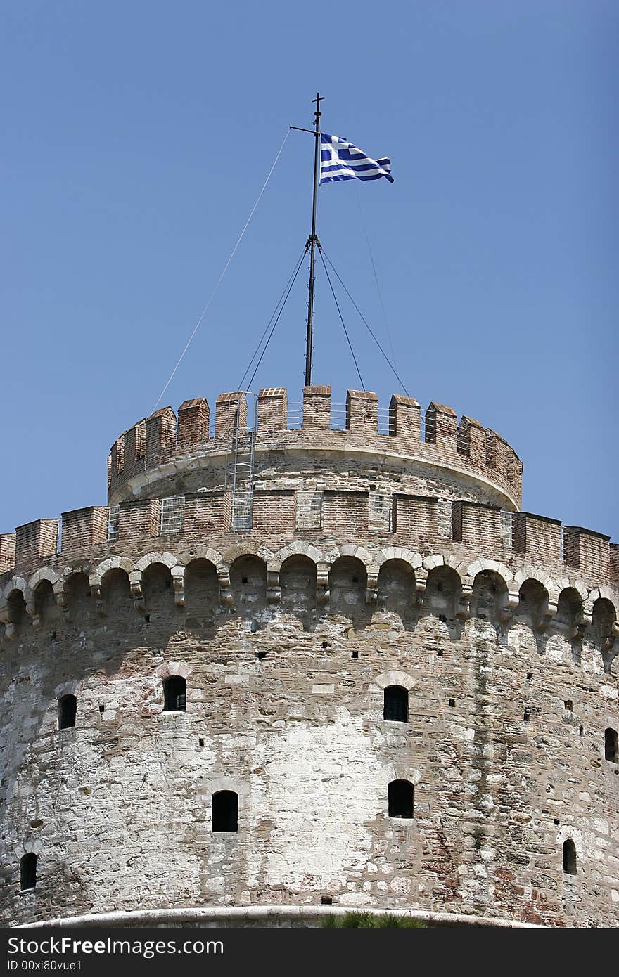 City tower in thessaloniki with greece flag on the top