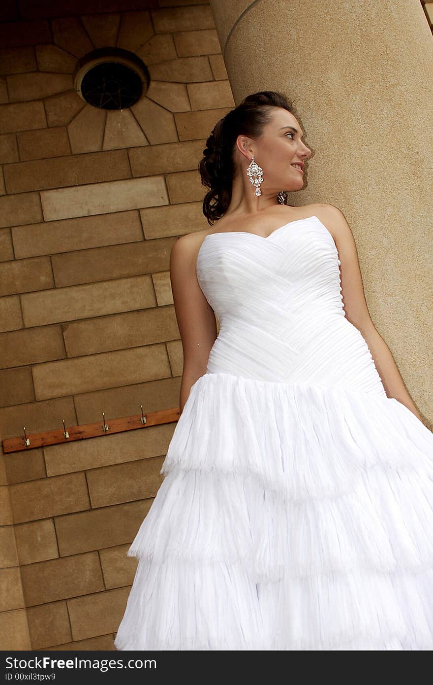 A bride standing next to a chapel. A bride standing next to a chapel