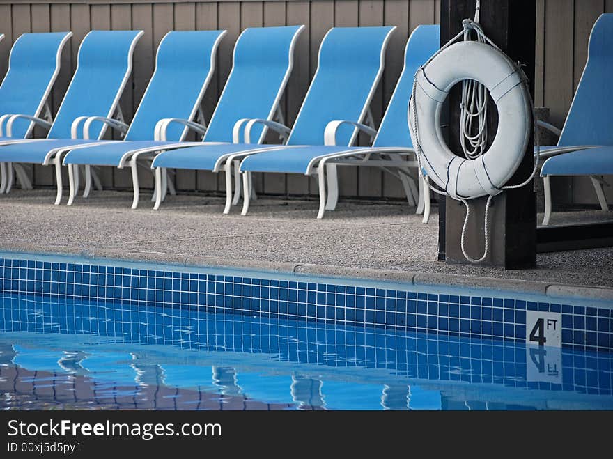 Swimming pool with life preserver and matching chaise lounges. Swimming pool with life preserver and matching chaise lounges.