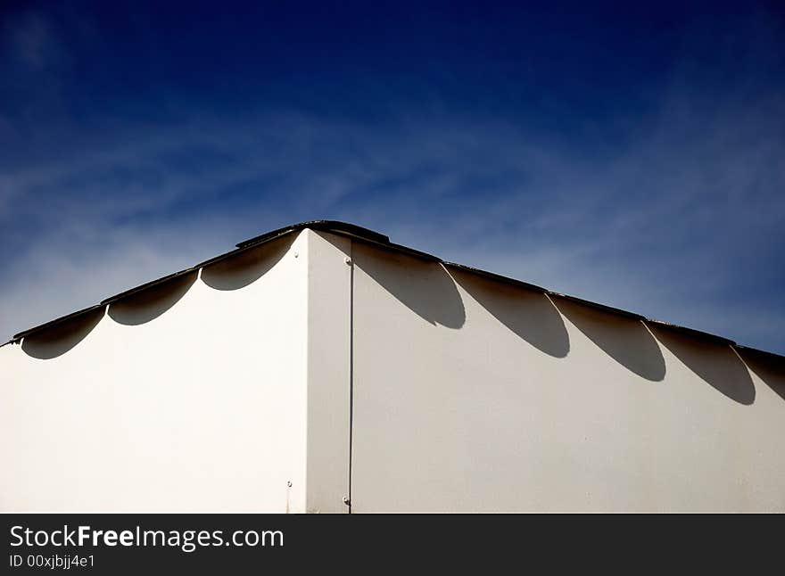 A minimalist shot of a roof edge with a colorful bright sky with clouds in the background. A minimalist shot of a roof edge with a colorful bright sky with clouds in the background