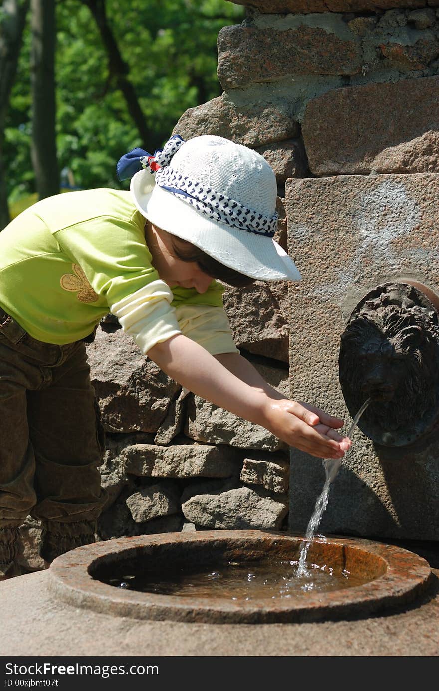 Child and fresh water in fountain