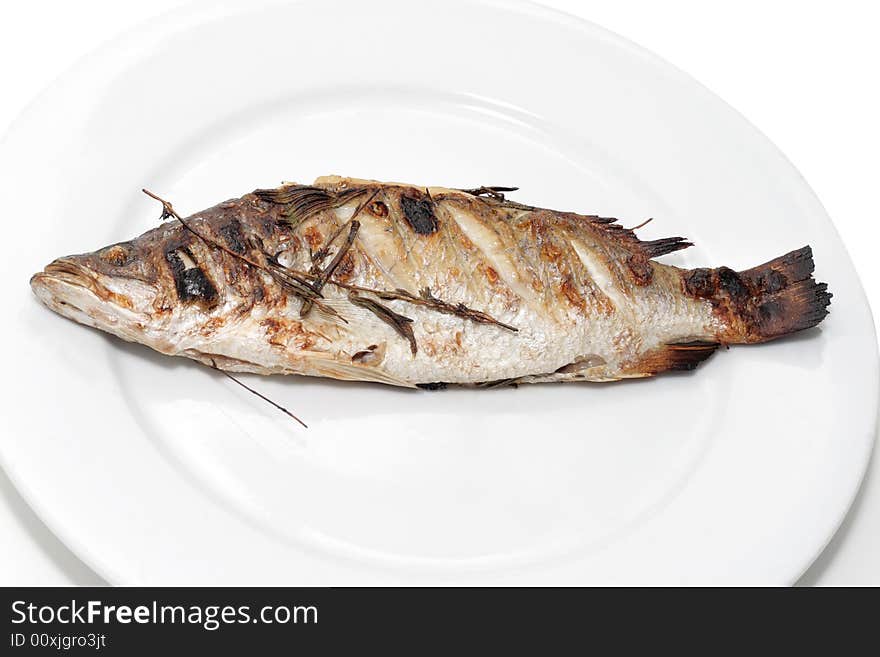 Sea bass with rosemary on a plate.