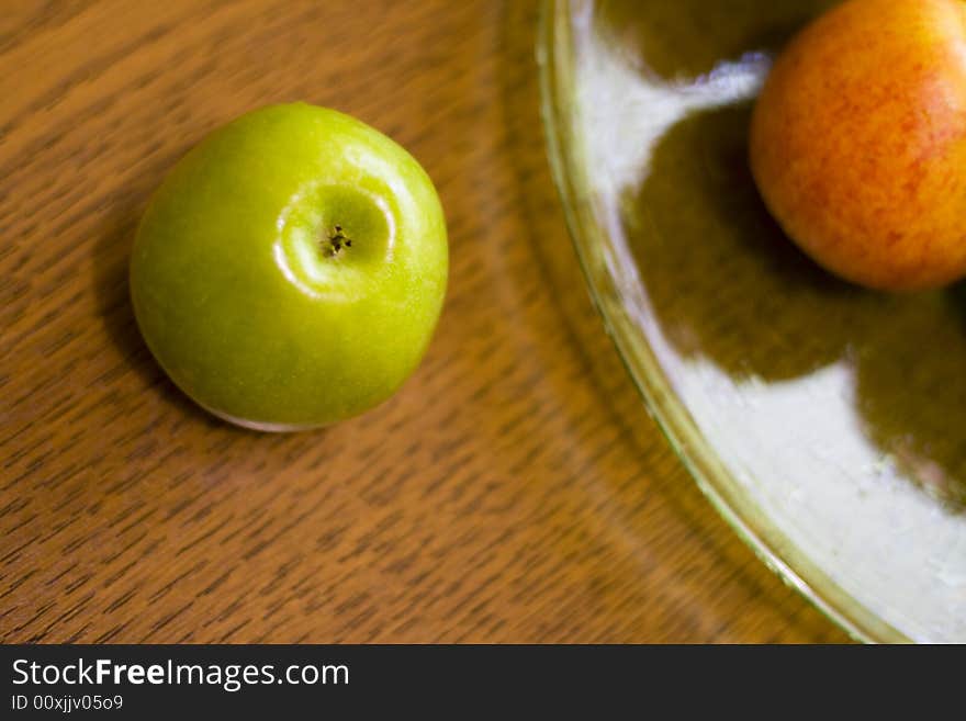 Green apple and plate on table