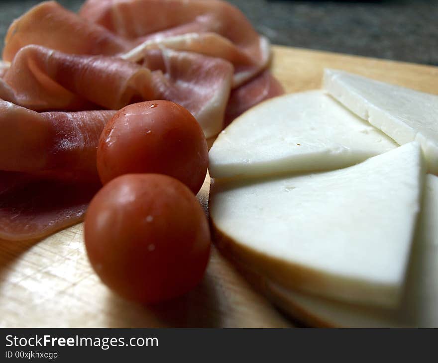 Platter of serrano ham, cherry tomatoes and smoked goat's cheese. Platter of serrano ham, cherry tomatoes and smoked goat's cheese