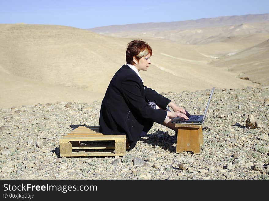 Young woman working with laptop in Judean desert. Young woman working with laptop in Judean desert