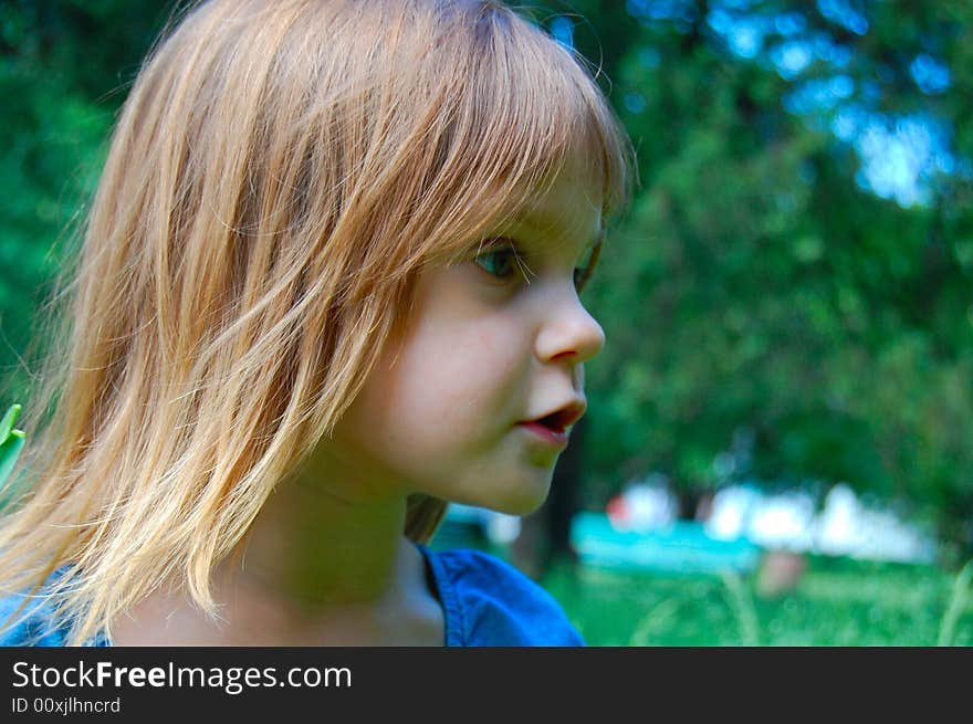 Pretty girl's portrait on the green outdoor background