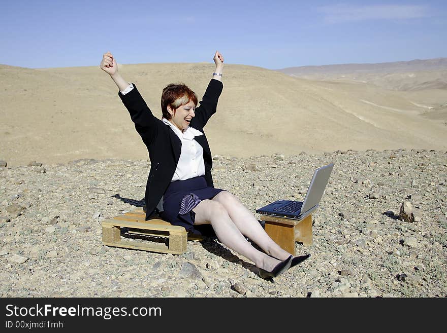 Young woman working with laptop in Judean desert. The successful transaction. Young woman working with laptop in Judean desert. The successful transaction.