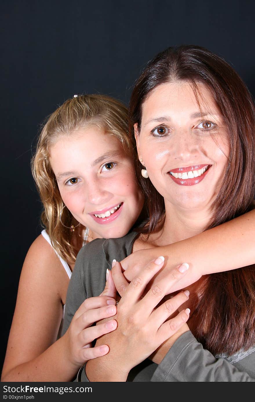 Beautiful mother and daughter on a black background