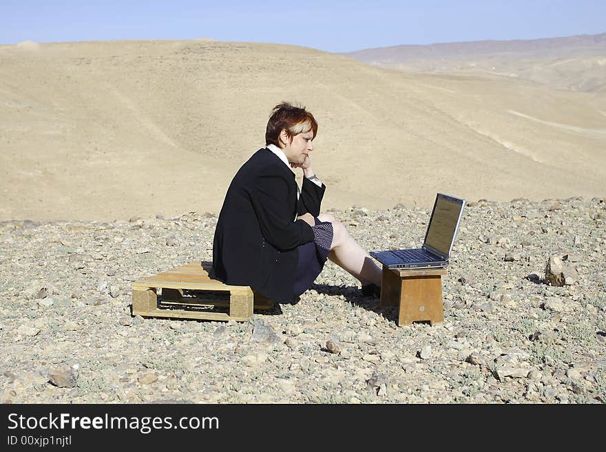 Young woman working with laptop in Judean desert. Young woman working with laptop in Judean desert