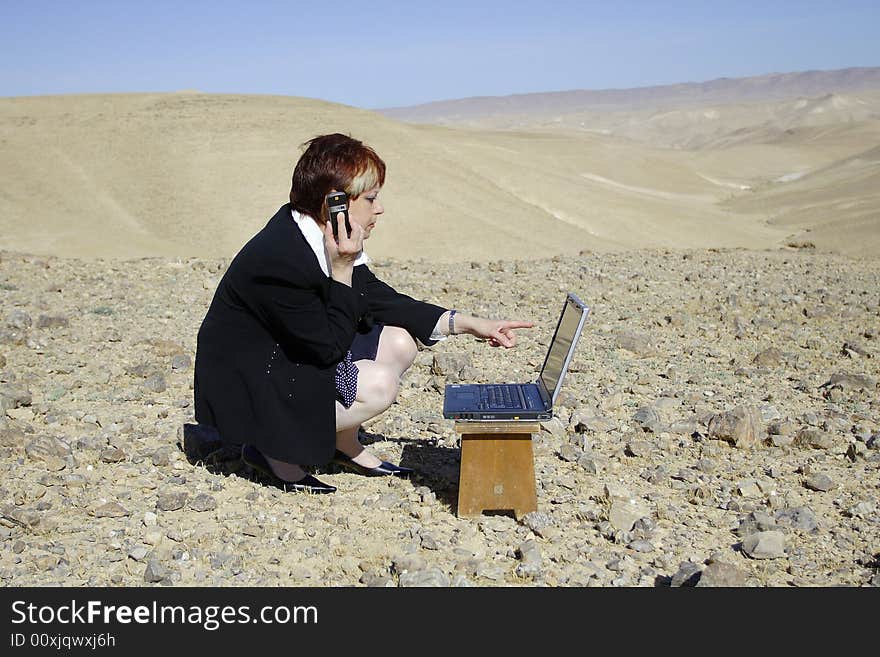 Young woman working with laptop in Judean desert. Young woman working with laptop in Judean desert