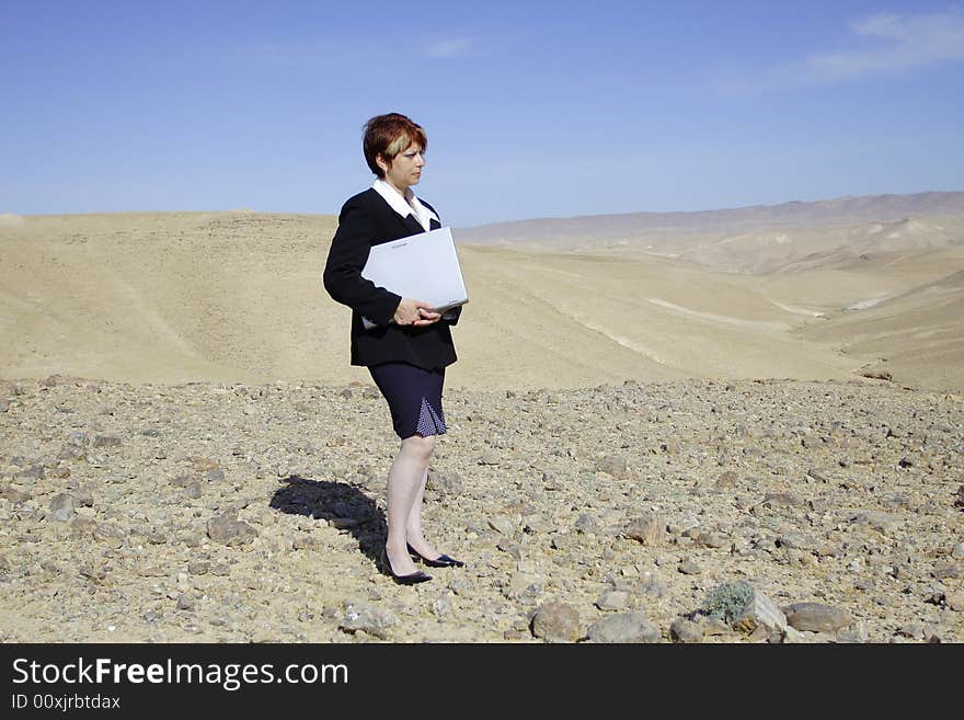 Young woman working with laptop in Judean desert. Young woman working with laptop in Judean desert