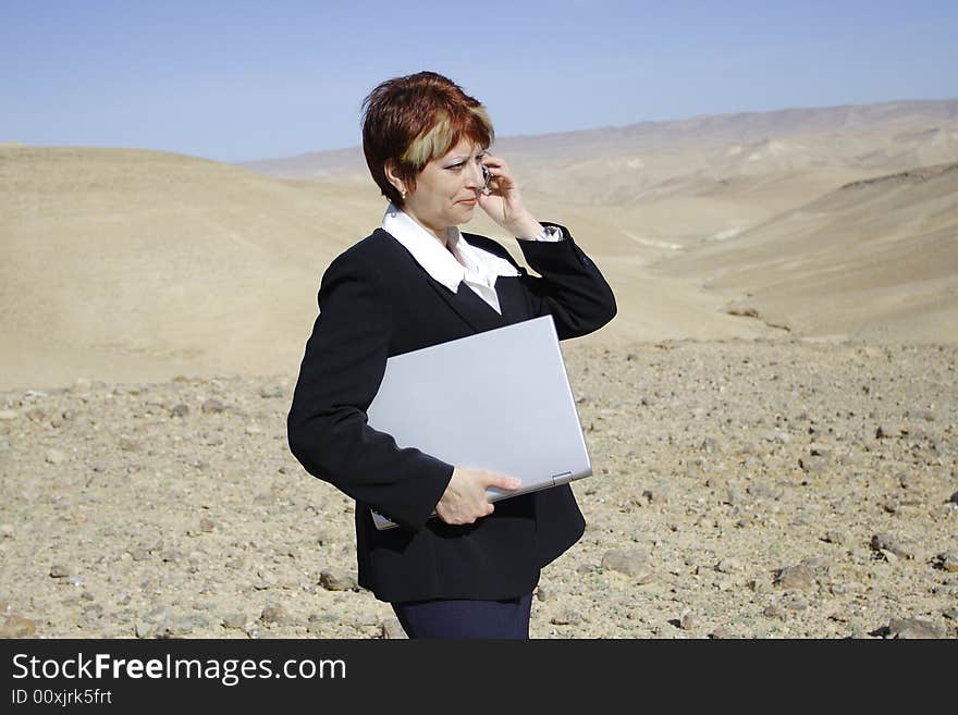 Young woman working with laptop in Judean desert. Young woman working with laptop in Judean desert