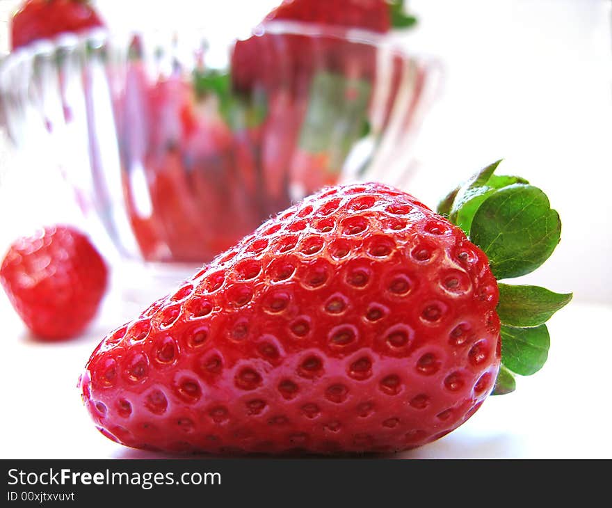 A strawberry with other strawberries in the white background