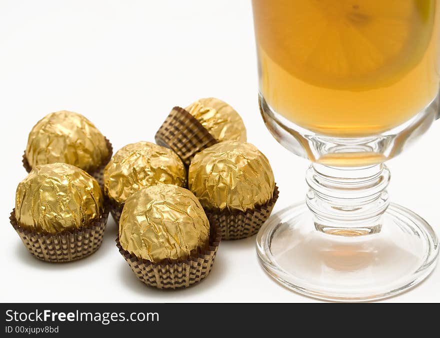 Tea with a lemon in glass chake and candies.